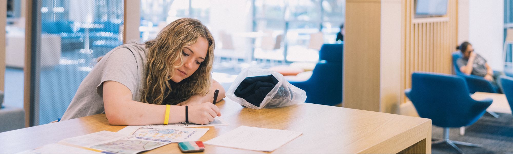 Student sitting and writing note in the Student Union.