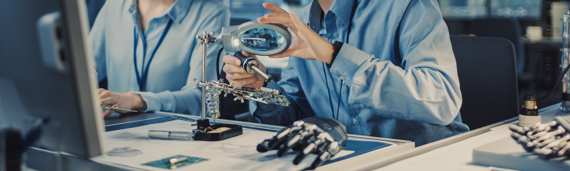 Two scientists building a robotic hand.