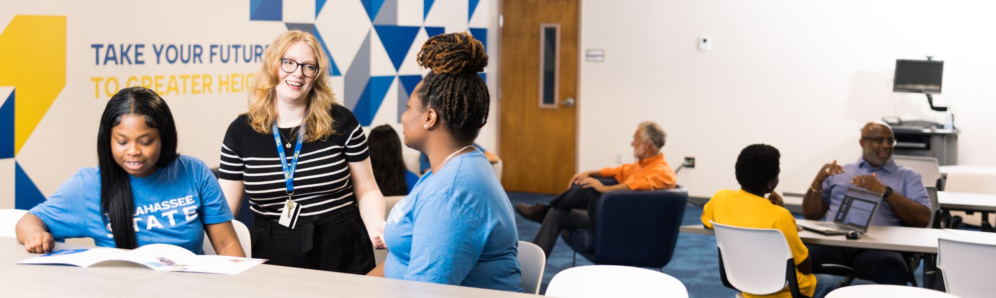 Adviser smiling and talking with a student.