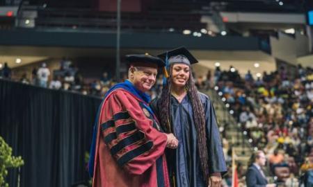 President Murdaugh shaking the hand of a graduating student.