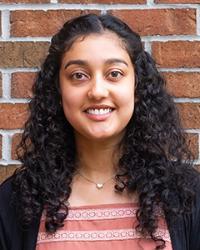 Ananya standing in front of a brick wall