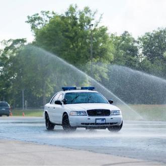 FPSI police training car going through wet road course.